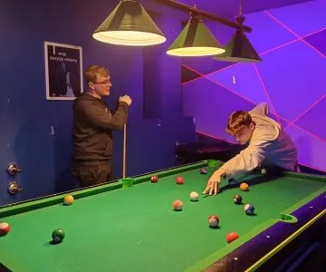 uczniowie grają w bilard