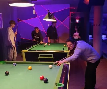 uczniowie grają w bilard