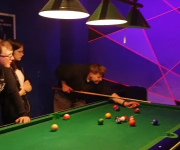 uczniowie grają w bilard